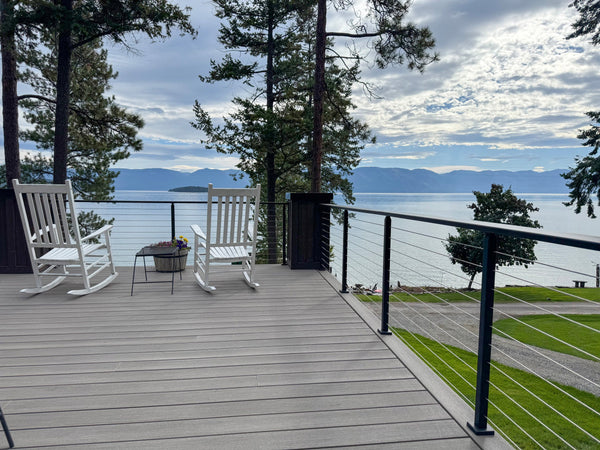 Elevated deck with black cable railing and a water view